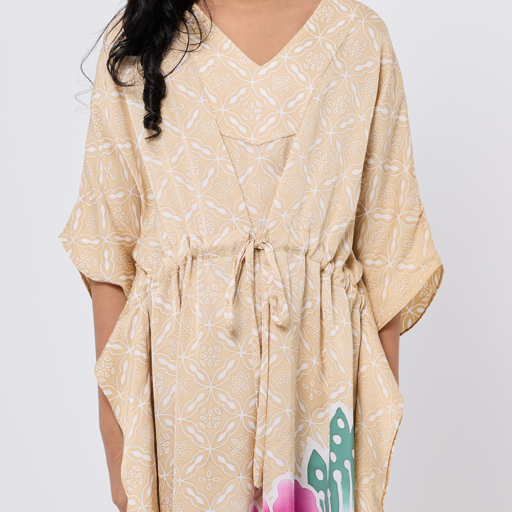 Beige patterned dress worn by a person on a white background