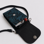 A black crossbody wallet with a dark teal dragon-patterned flap, shown open to reveal card slots and a red pen inside, on a light gray background.