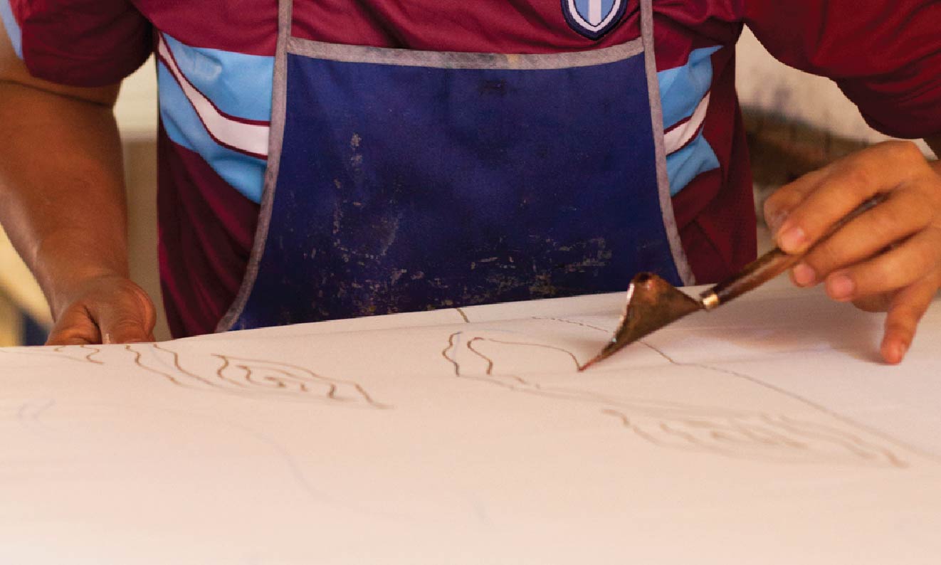 Skilled batik artisans carefully crafting traditional patterns using time-honored techniques.