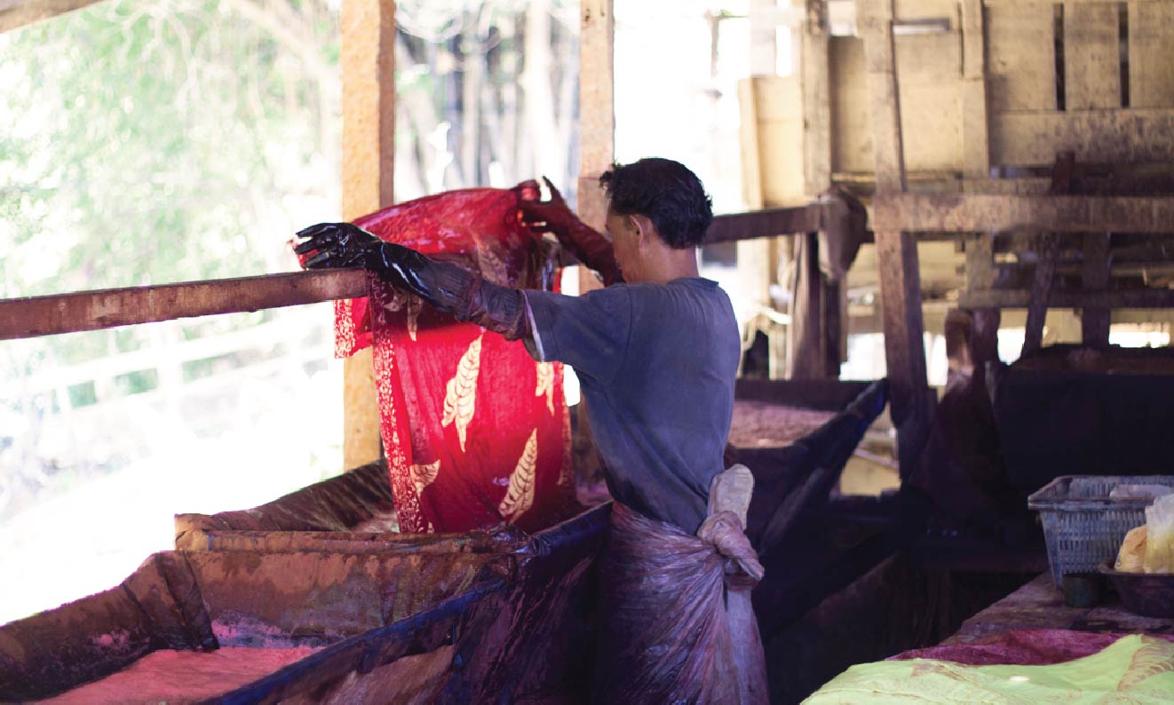Skilled batik artisans carefully crafting traditional patterns using time-honored techniques.