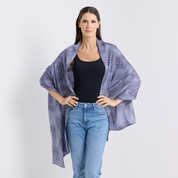 Woman wearing a patterned kimono over a black top and blue jeans on a white background