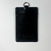 Black leather cardholder with key ring on a light gray background