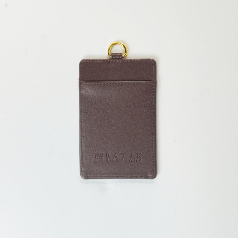 Brown leather cardholder with gold ring on a white background