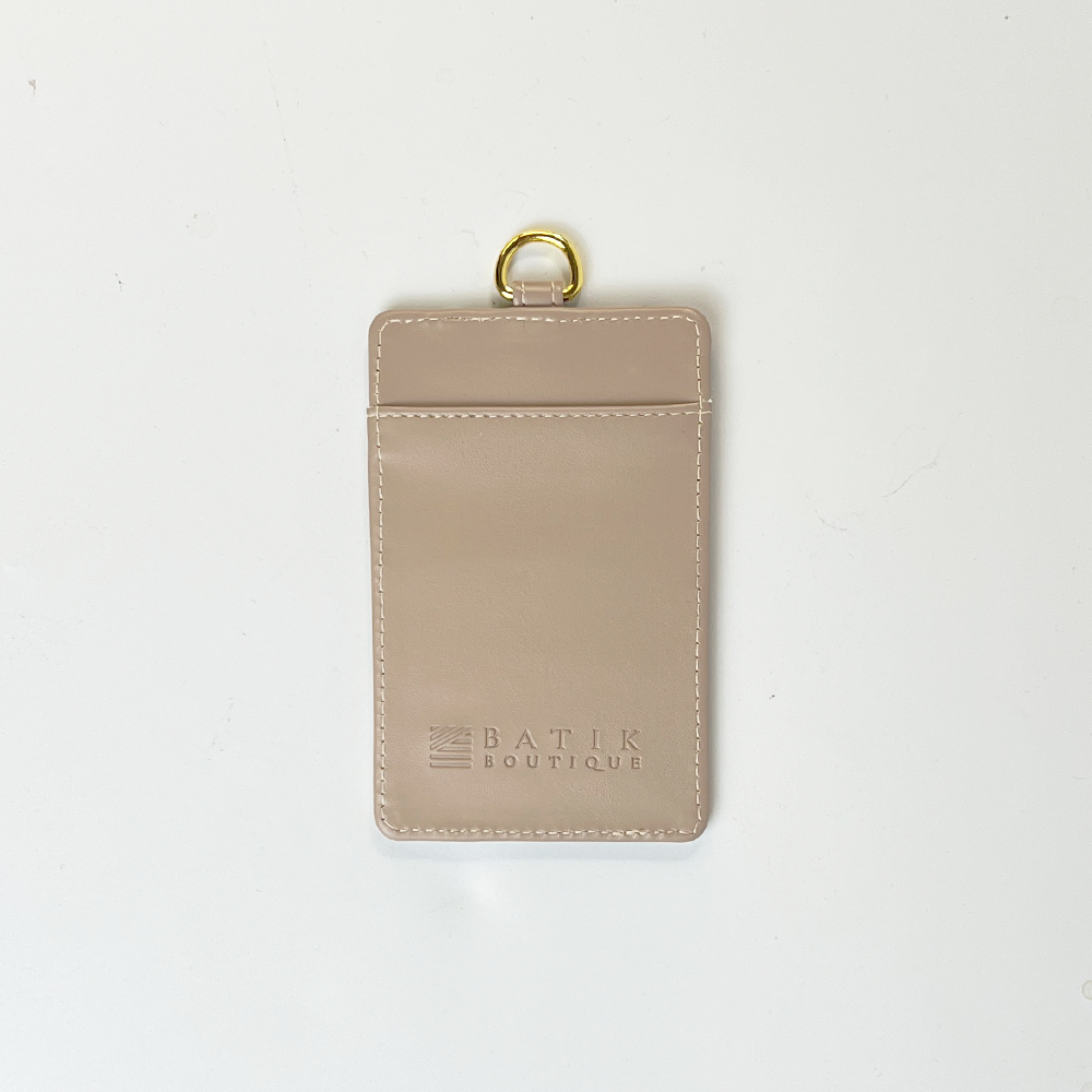 Beige cardholder with gold ring on a white background