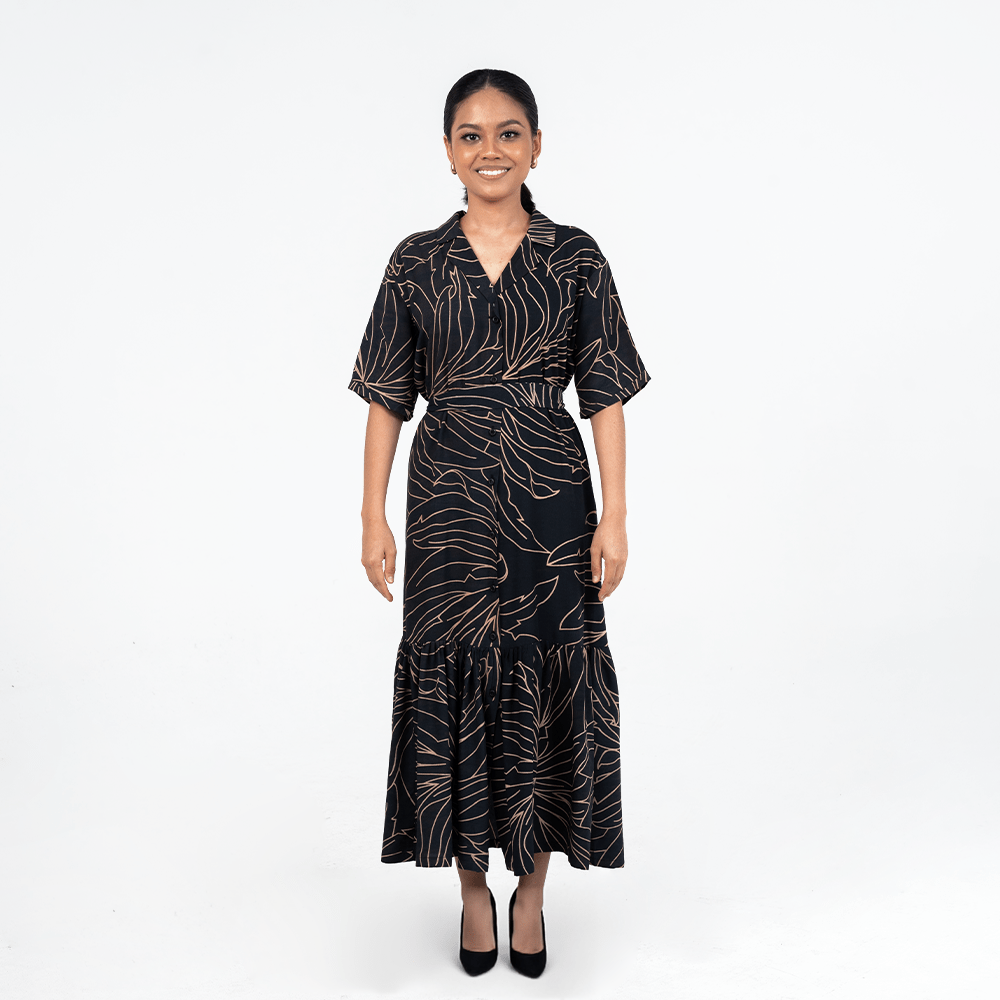 Front view of Batik Boutique’s Onyx Palma Button-Up Dress in black with soft gold botanical lines, styled with a flattering waist tie