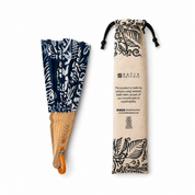 A batik folding hand fan with a navy blue and white pattern and a natural wood handle, shown next to its beige drawstring storage pouch printed with 'BATIK BOUTIQUE'.