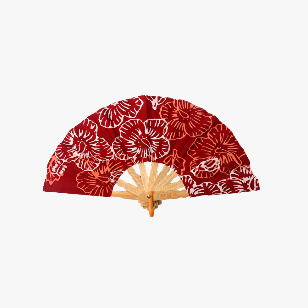A folding hand fan with a red fabric canopy featuring a white and orange floral pattern, supported by a light wood frame.