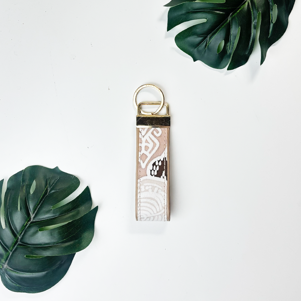 Keychain with decorative pattern on a white background with green leaves