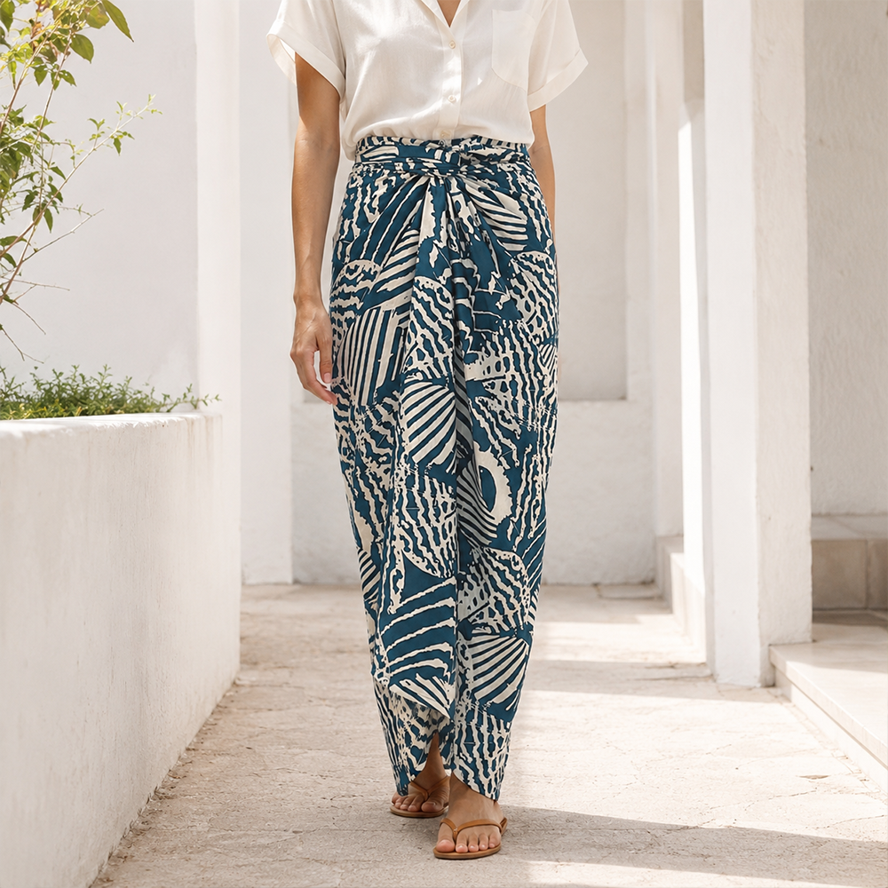 Person wearing blue and white patterned pants walking on a wooden path.