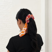 Lady wearing orange and pink gradient batik scrunchy