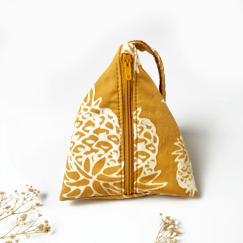 Yellow fabric pouch with white floral patterns and a zipper on a white background