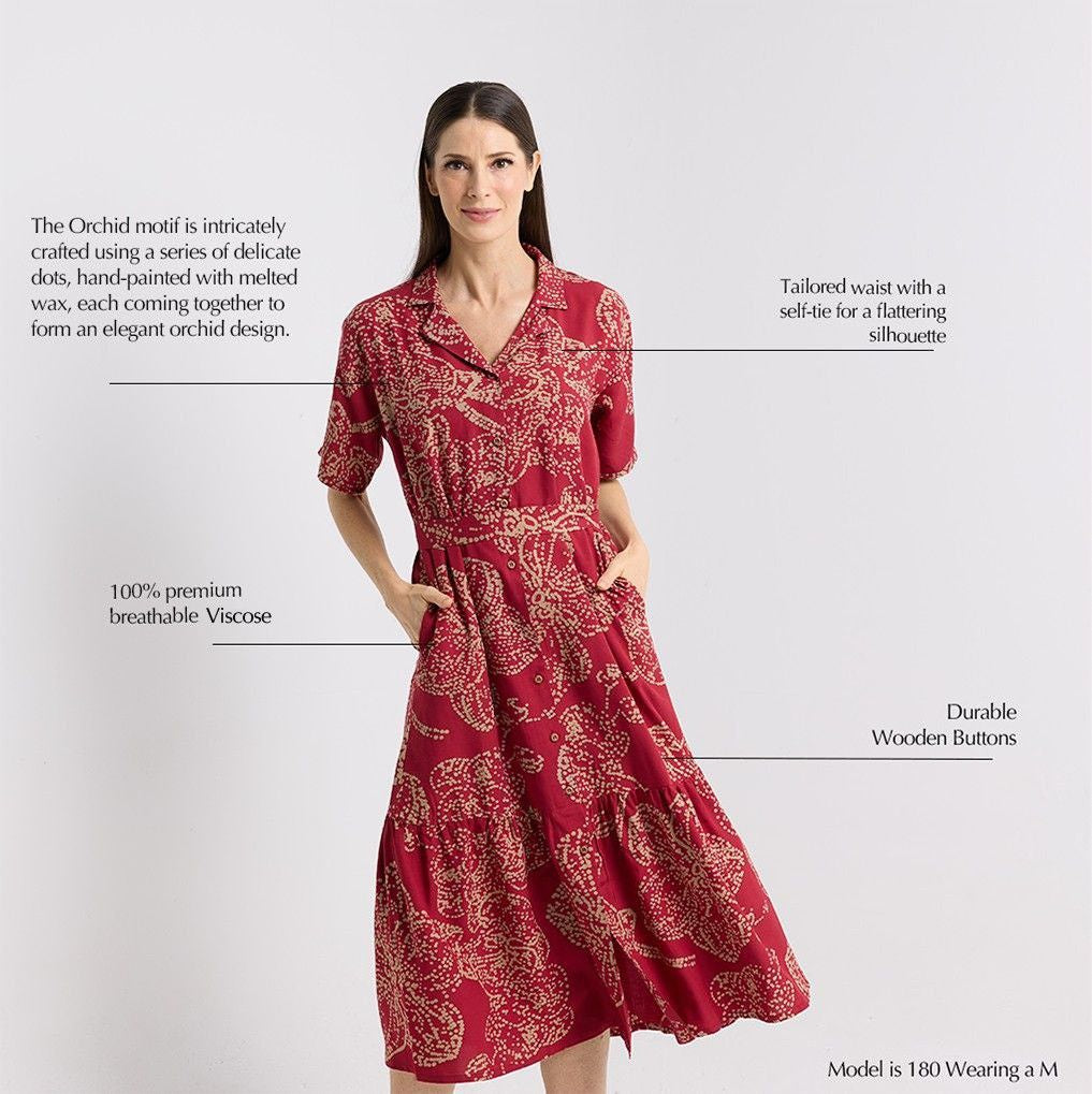 Red patterned dress worn by a model on a light gray background