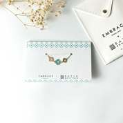 Jewelry card with a necklace design on a white surface with 'Embrace Batik Boutique' branding.
