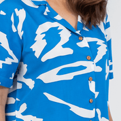 Close up photo of the blue rimba women's cuban shirt showcasing the wooden buttons and bright 
