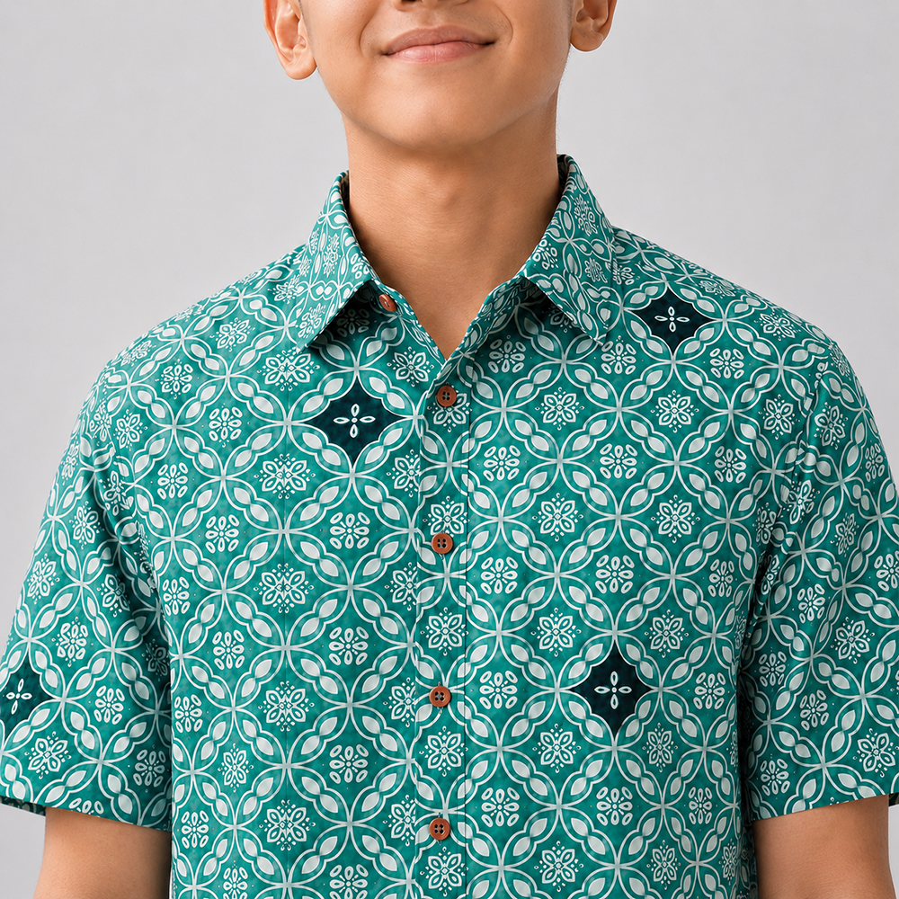 Person wearing a green patterned shirt against a gray background