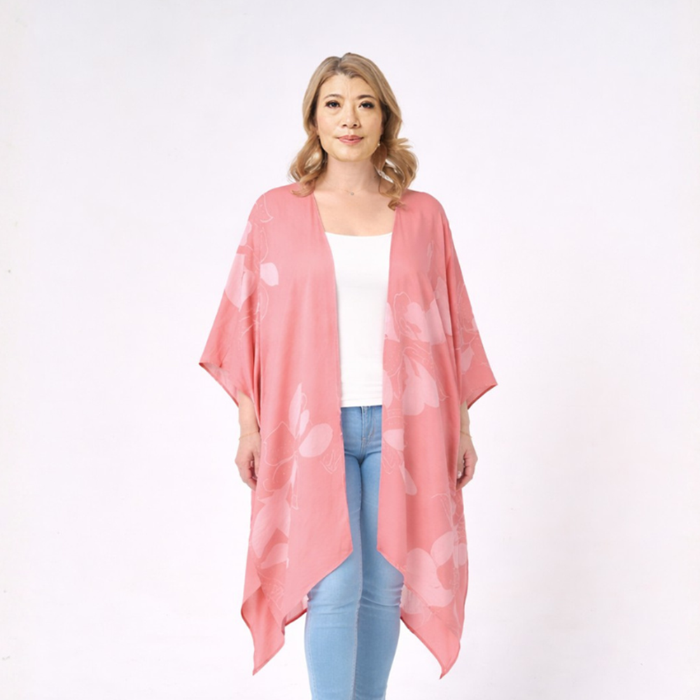 Woman wearing a pink floral kimono over a white top and blue jeans on a white background