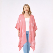 Woman wearing a pink floral kimono over a white top and blue jeans on a white background