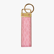 A pink textured leather keychain strap with a gold-tone metal ring and a matching gold-tone metal cap featuring two small pink rhinestone accents, shown on a plain light gray background.
