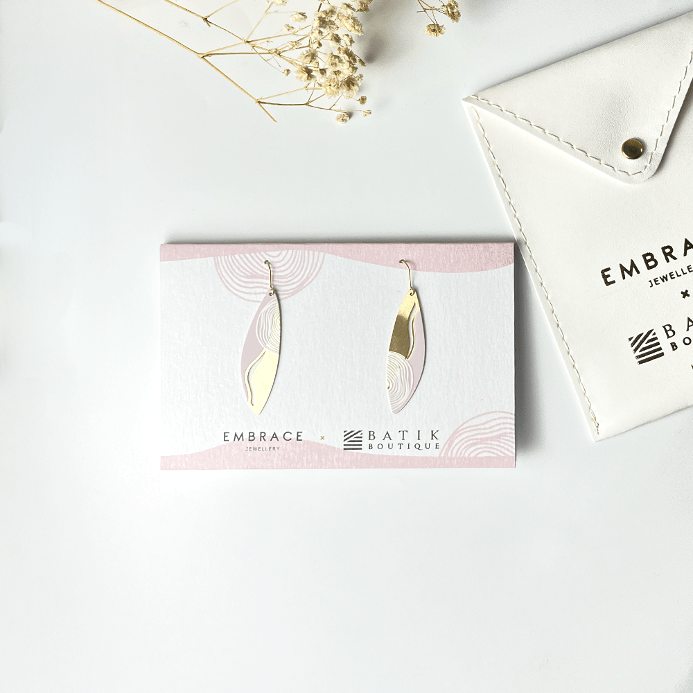 Earrings on a card with 'Embrace Batik Boutique' branding, placed on a light surface.
