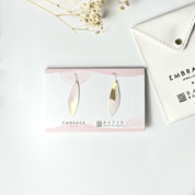 Earrings on a card with 'Embrace Batik Boutique' branding, placed on a light surface.