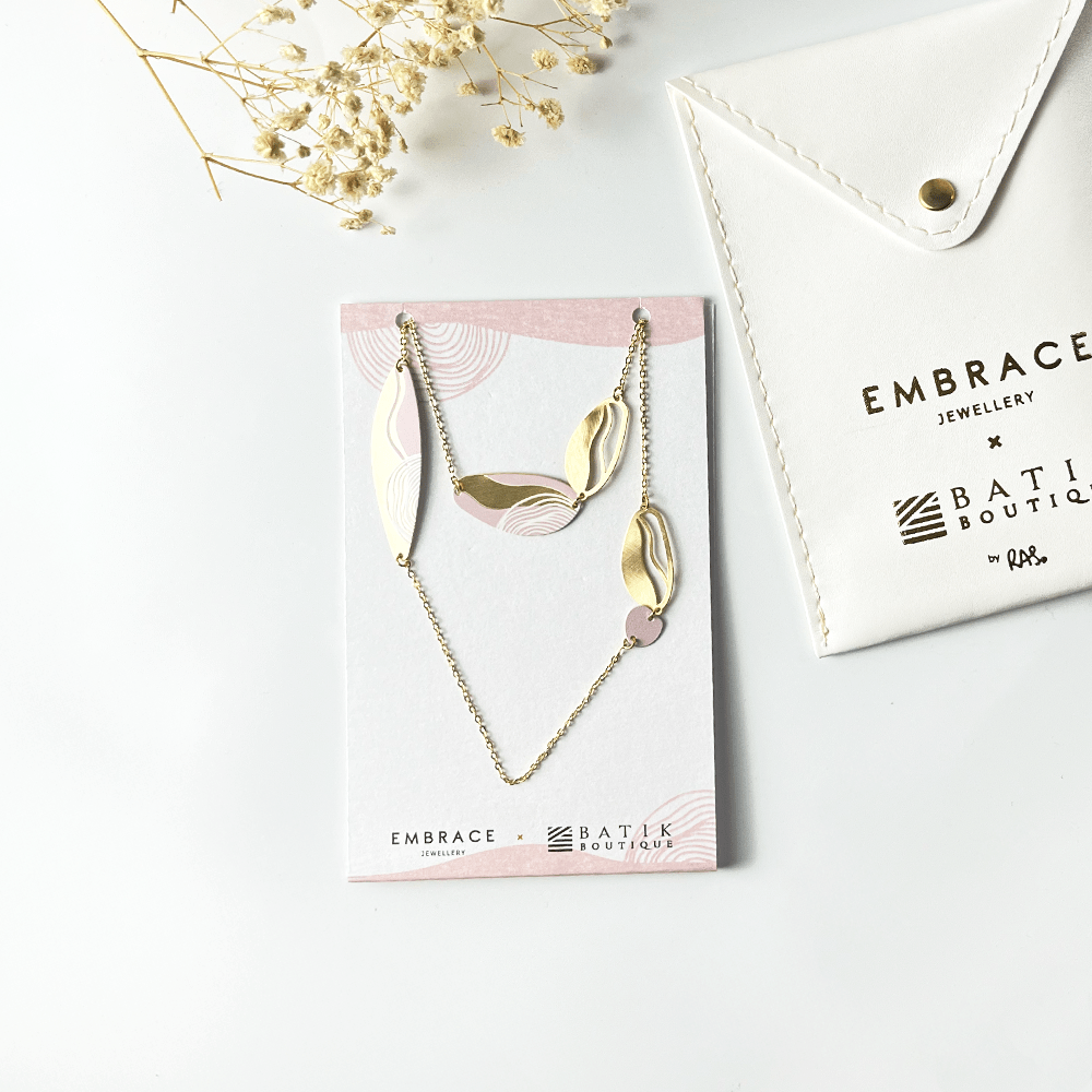 Gold necklace on a card with 'Embrace Jewellery' branding, placed on a white surface.