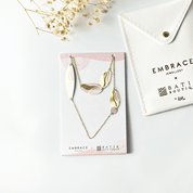Gold necklace on a card with 'Embrace Jewellery' branding, placed on a white surface.