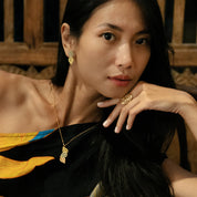 Woman wearing gold jewelry with a dark background