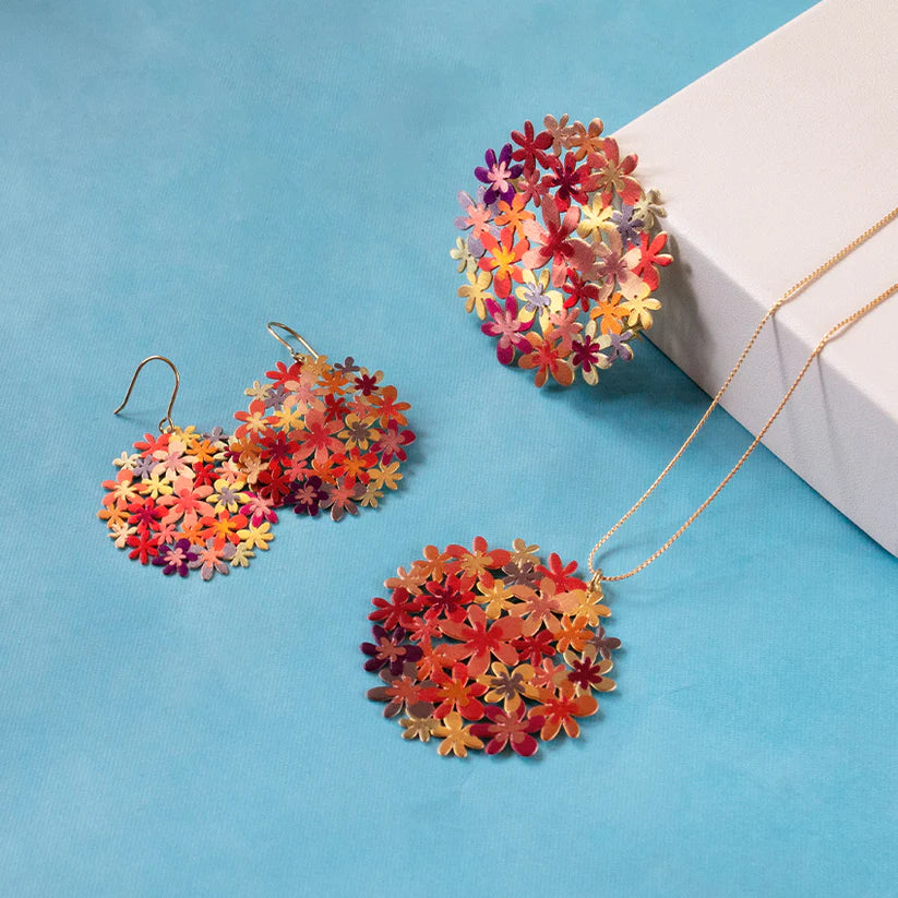 Colorful floral earrings and necklace on a blue background