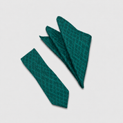 A dark green necktie and matching pocket square set with a subtle diamond lattice pattern, arranged on a light gray background.