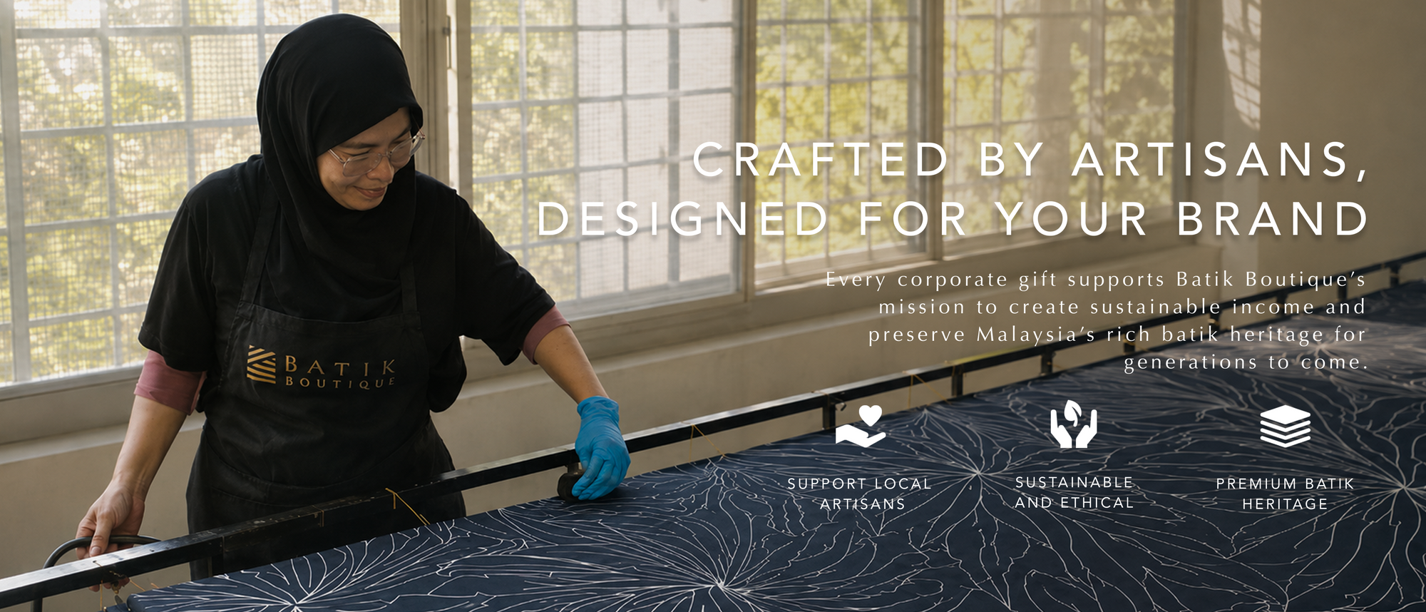 Woman working with batik fabric in a workshop, with text about supporting artisans and brand values.
