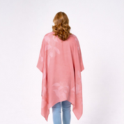 Person wearing a pink floral kimono-style garment on a white background