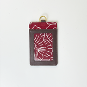 Card holder with red floral pattern on a white background