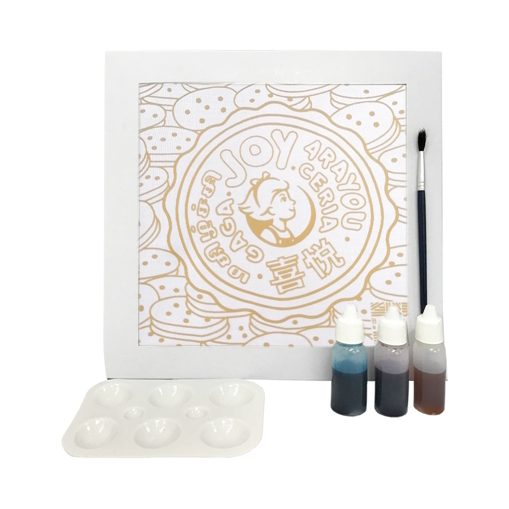 Coloring book with gold designs, paint bottles, and a brush on a white background