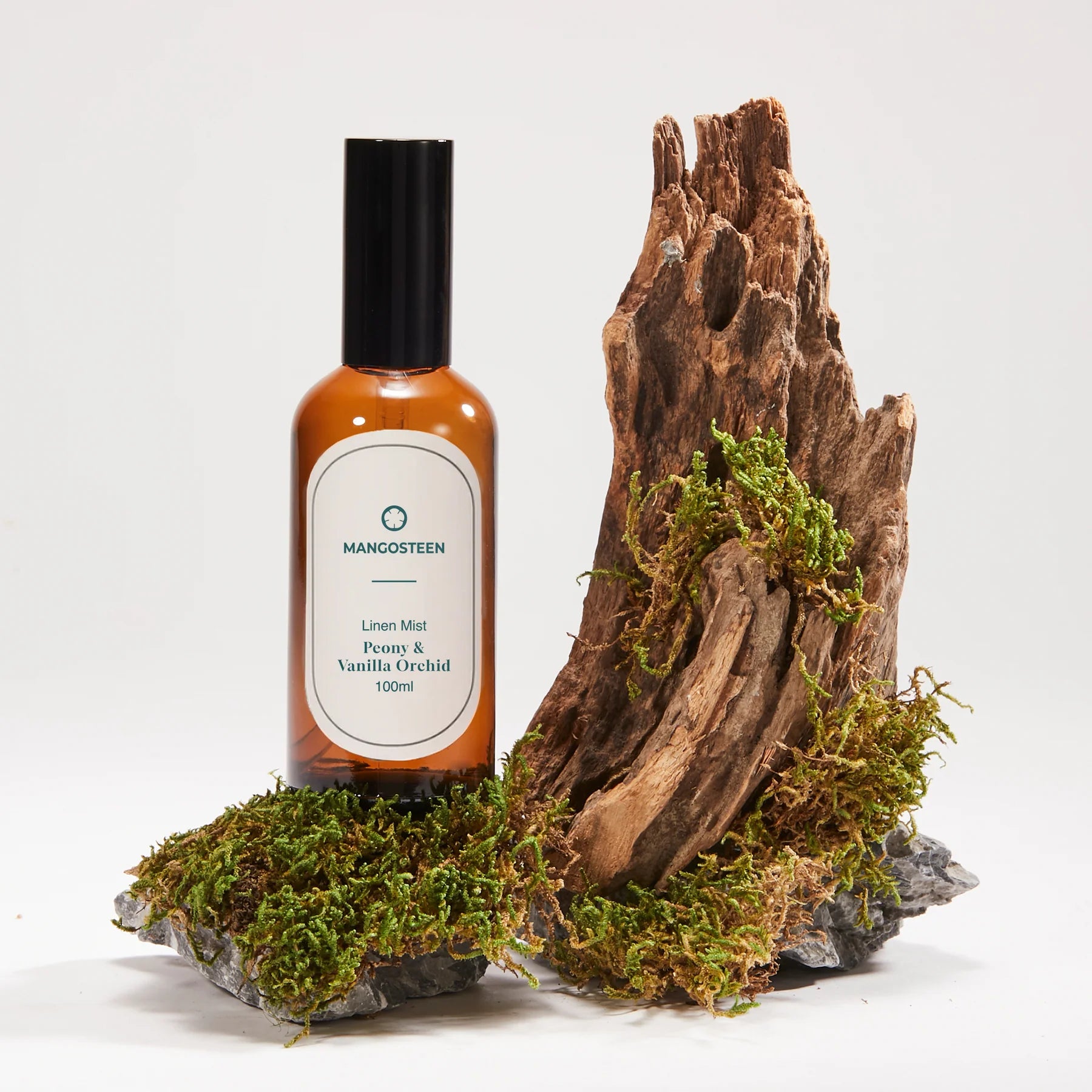 Bottle of Mangosteen product on a natural wooden and moss background