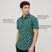 Man wearing a green patterned Batik shirt on a light gray background