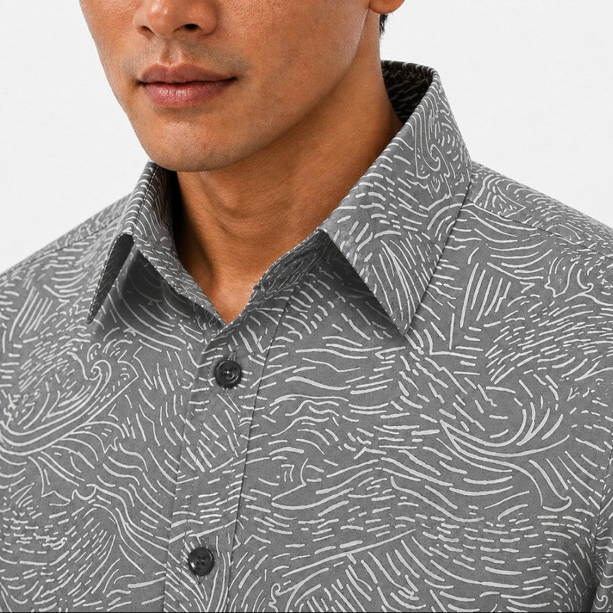 Man wearing a gray patterned shirt with a close-up of the collar.
