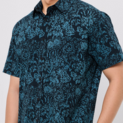 Person wearing a blue patterned shirt on a white background