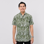Man wearing a green and white patterned shirt on a gray background