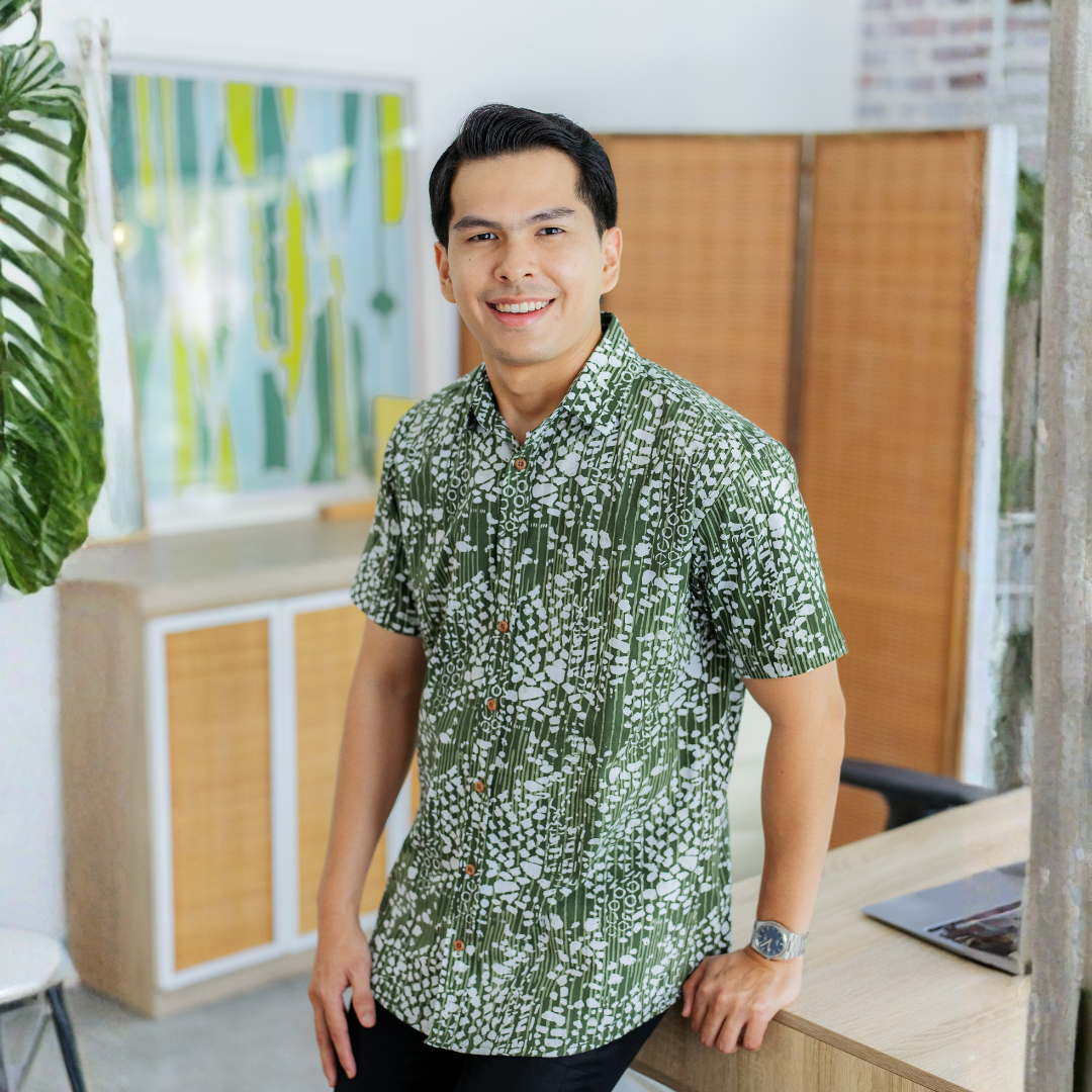 Man wearing a green patterned batik shirt in an office setting