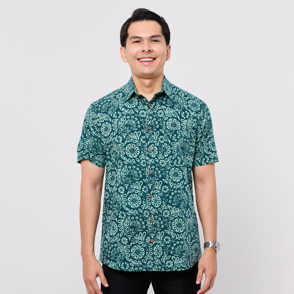 Man wearing a green patterned Batik shirt on a white background
