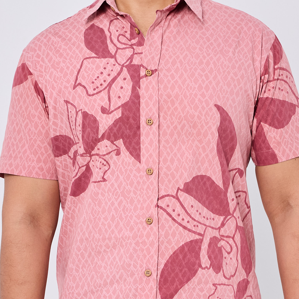 Pink floral patterned shirt on a plain background