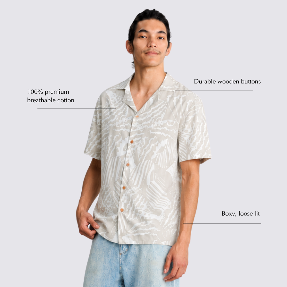 Man wearing grey printed batik shirt looking into the camera, with detailed annotations by his sides