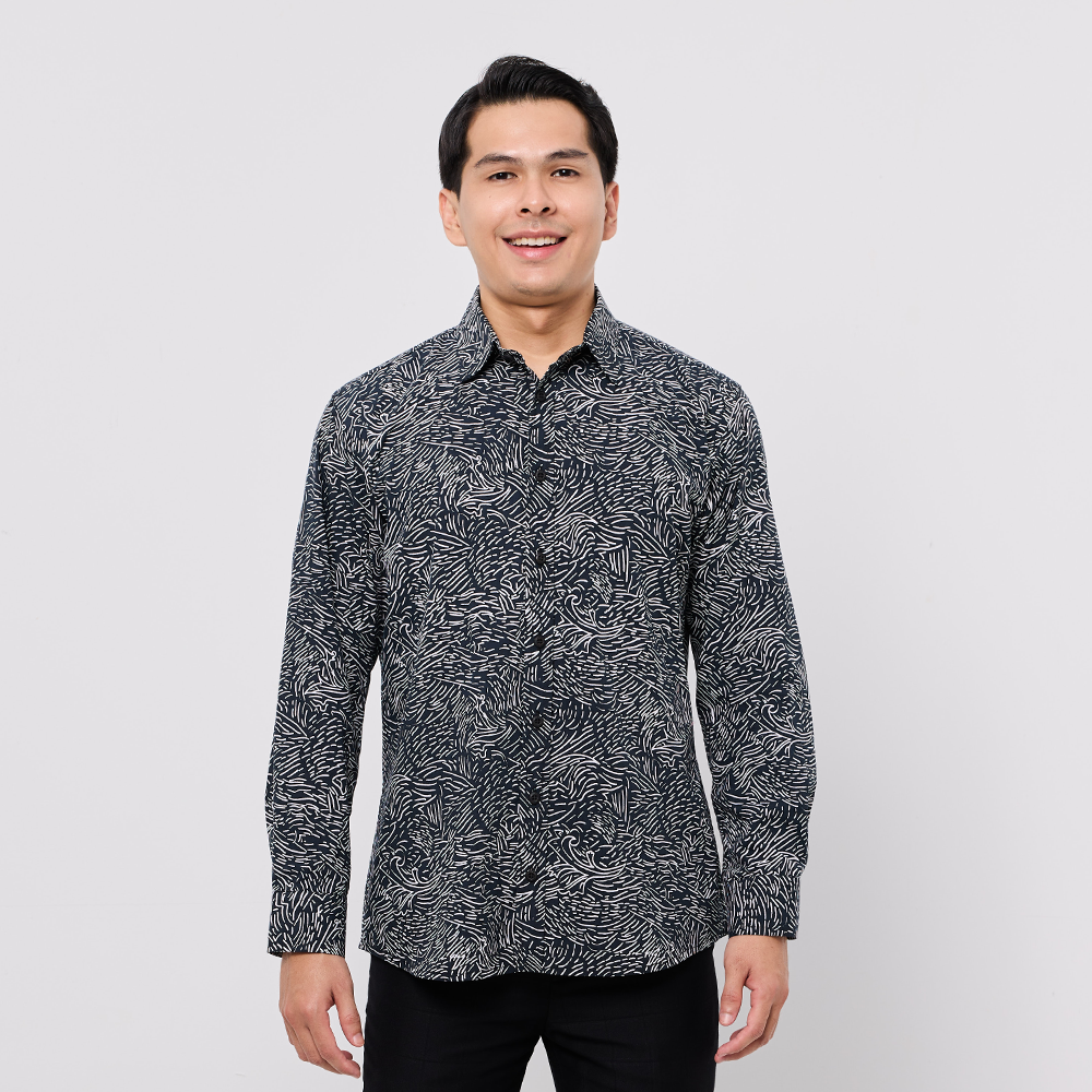 Man wearing a black patterned shirt against a white background