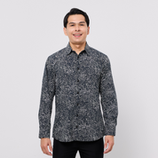 Man wearing a black patterned shirt against a white background
