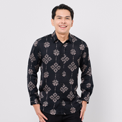 Man wearing a black patterned shirt against a white background