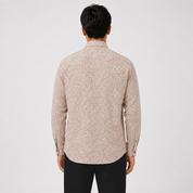 Man wearing a beige patterned shirt on a white background