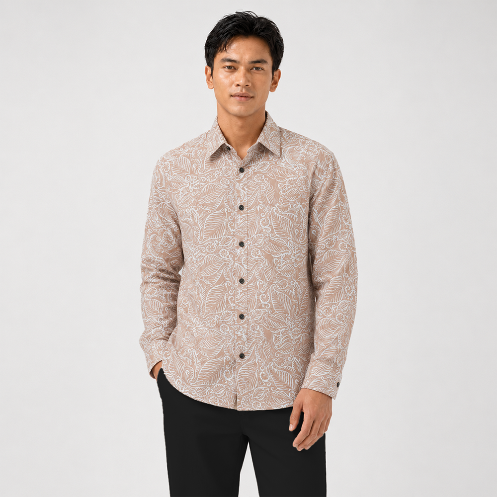 Man wearing a patterned beige shirt on a white background