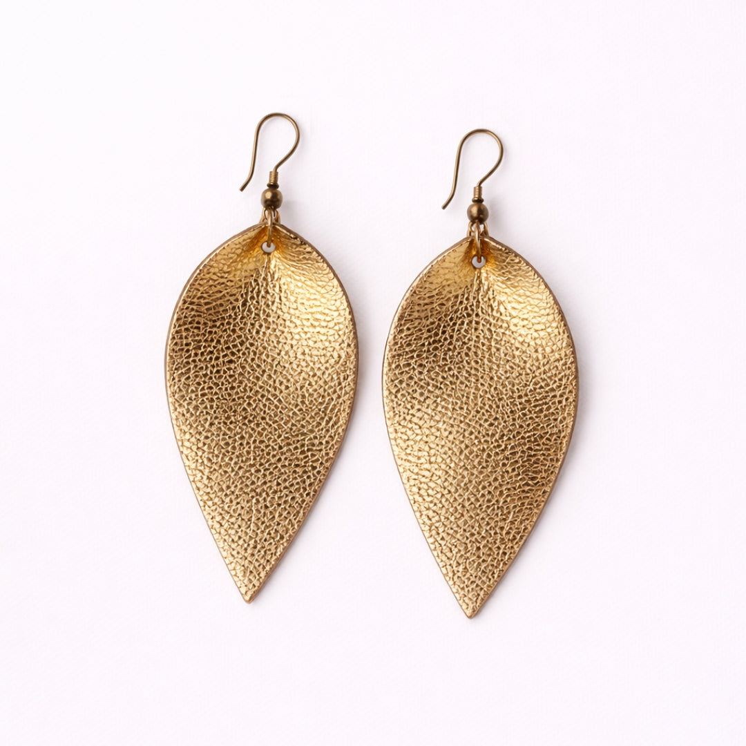 Gold leaf-shaped earrings on a white background