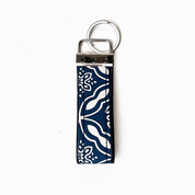 A vertical keychain with a navy blue and white patterned fabric strap and a silver metal split ring, shown on a plain white background.