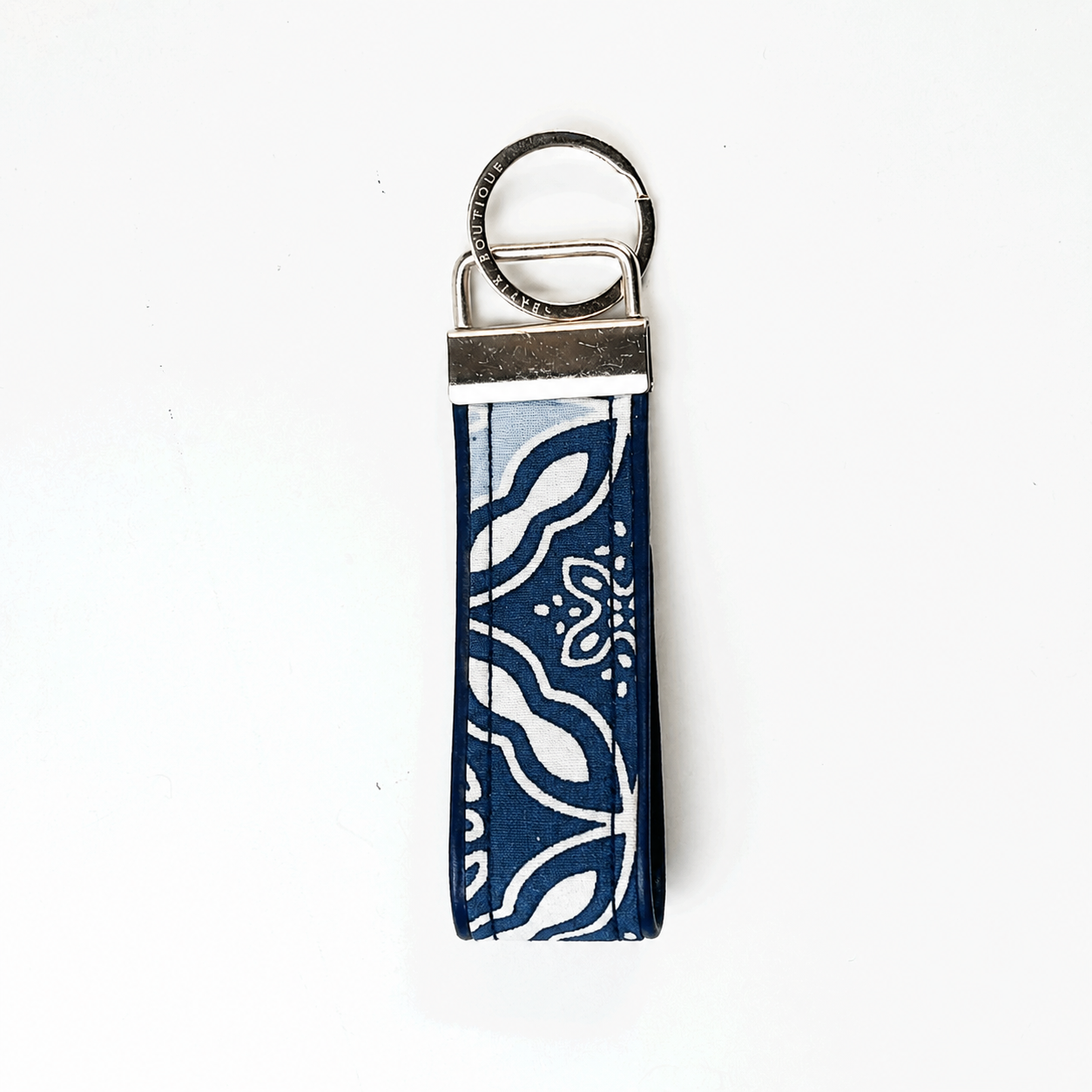 A fabric keychain strap with a navy blue and white bandana-style pattern, attached to a silver metal split ring and slider clasp, shown on a plain white background.